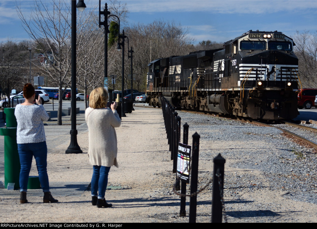Two ladies from out of town take pictures of NS yard job E19 returning lite to Montview Yard